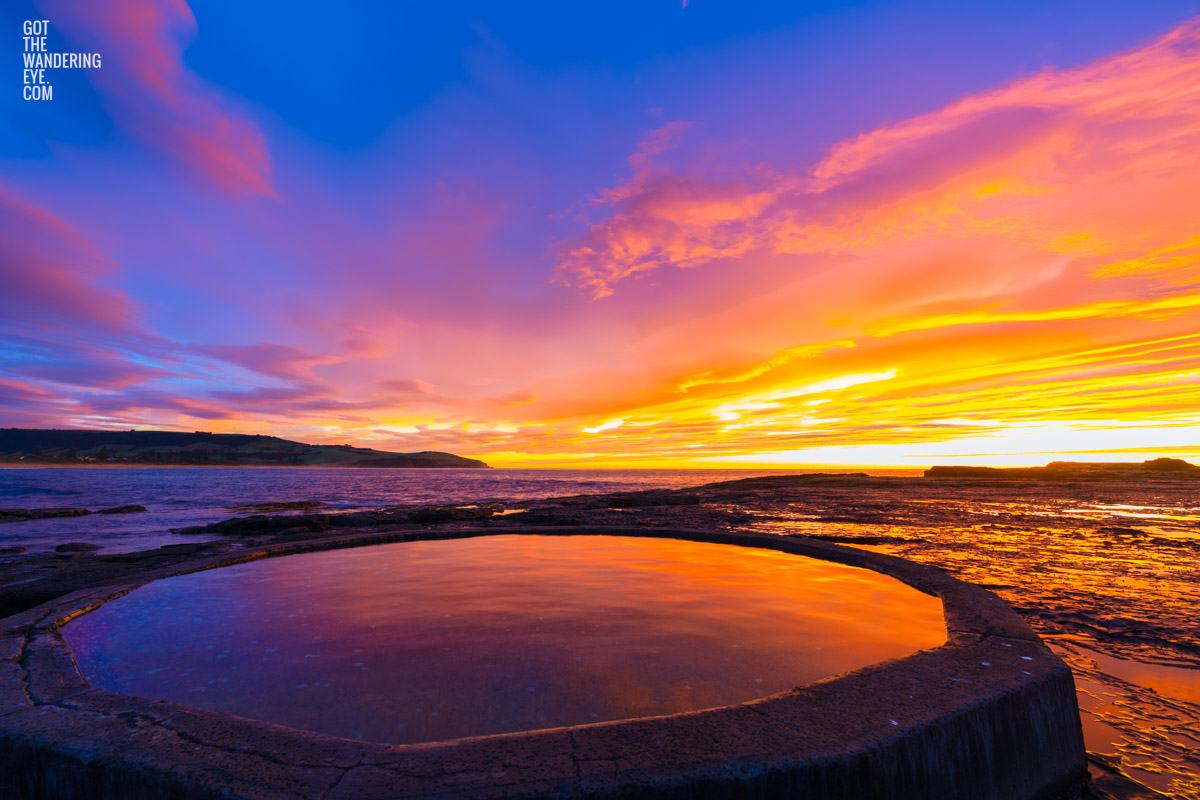 Fiery sunrise over Ourie Pool Werri Beach in NSW South Coast.