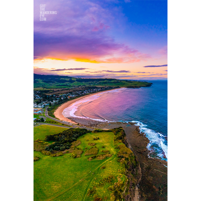 Aerial above Gerringong headland looking back at a purple sky sunset over Werri Beach.