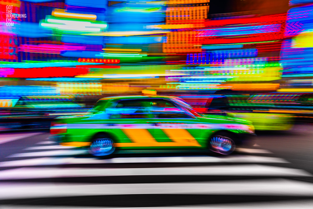 Tokyo Taxi Long Exposure night neon lights streaking in Shinjuku with the iconic striped green and yellow Tokyo Taxi.